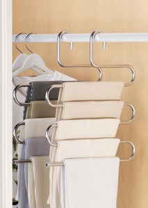 Space-saving S-shaped stainless steel pants hanger holding multiple trousers in a wardrobe