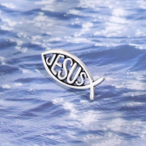 Silver metal fish brooch with Jesus hollow engraving on blue ocean ripple background