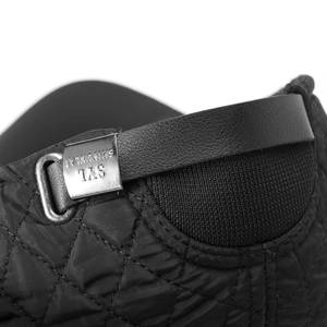 Detail of winter baseball cap with quilted fabric, leather strap, and silver metal buckle