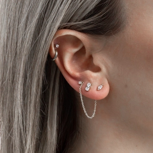 Detailed view of S925 silver eye tassel earrings with zircon studs on model's ear