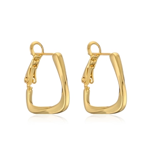 Detail of twisted gold geometric C-shaped hoop earrings with professional polished finish