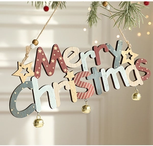 Detail of wooden Merry Christmas hanging sign with golden bells on pine branch decoration