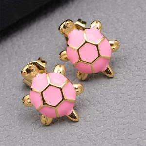 Close-up of cute golden turtle stud earrings with pink enamel finish for women