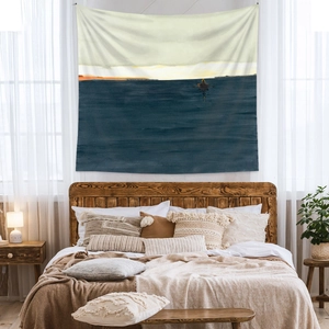 Detail of bohemian tapestry featuring an oil painting sea landscape above a bed