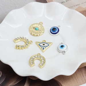 DIY Evil Eye and Horseshoe Triangle Pendants in Gold and Silver finish on ceramic plate