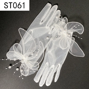 Detail of white bridal mesh glove with elegant 3D bow, pearls and delicate beaded tassels