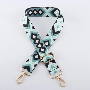 Detail of adjustable geometric diamond pattern bag strap with gold metal lobster clasps