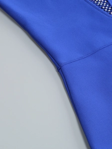 Détail de robe bandage bleue avec empiècements en maille transparente et strass étincelants