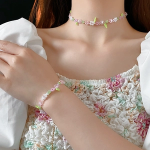 Detail of handmade flower beaded choker necklace and matching bracelet set on model
