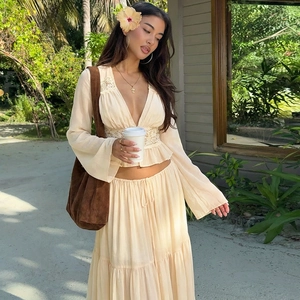 Close-up of deep V-neck lace trim crop top and flowing tiered chiffon skirt in beige