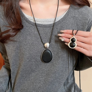 Détail de pendentifs minimalistes en bois ovale et gourde avec cadre argenté