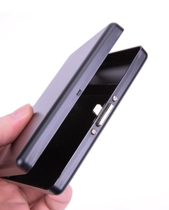 Macro detail of black metal cigarette case with brushed texture and spring mechanism