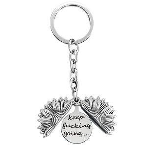 Detailed view of sunflower locket keychain with engraved motivational quote keep fucking going