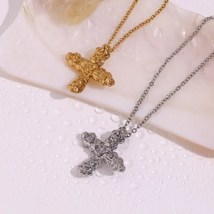 Macro view of textured 18K gold and silver cross pendants with molten metal finish