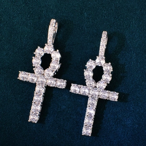 Macro view of silver Ankh cross pendants with inlaid cubic zirconia on velvet