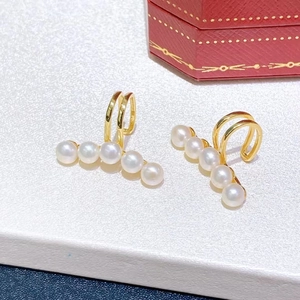 Elegant freshwater pearl ear clips in gold-plated setting on white silk background