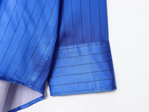 Detail of blue striped satin shirt showing high-quality stitching and smooth fabric texture