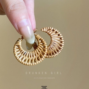 Detailed view of handmade raffia fan earrings in bohemian style with natural woven texture