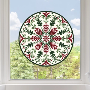 Close-up of a circular Christmas mandala window sticker on a glass pane with snowy background