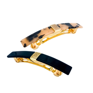 Detail of tortoise shell and black acetate hair clips with gold rhinestone embellishment