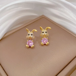 Macro shot of gold rabbit earrings featuring pink gemstones and micro-pave crystals