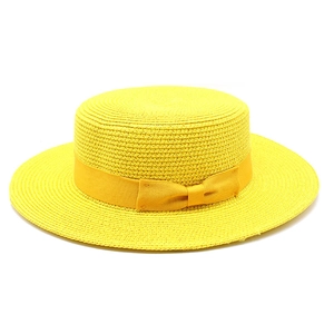 Close-up of yellow boater hat featuring fine woven texture and decorative ribbon bow