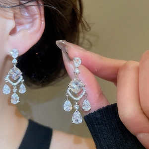 Detail of silver drop earrings with pear-shaped cubic zirconia tassels on ear