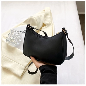 Detail of a black hobo shoulder bag with golden hardware and premium synthetic leather