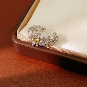 Macro shot of green zircon flower ring with sparkling pave stones and open silver band