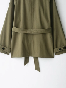 Detail of army green cotton trench coat back with decorative waist belt and cuff buttons