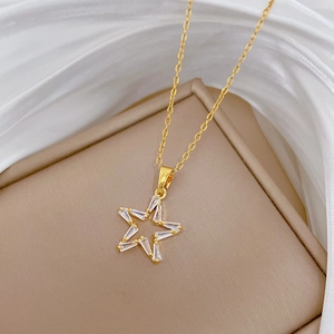 Detail of gold star pendant with baguette cubic zirconia stones on jewelry box