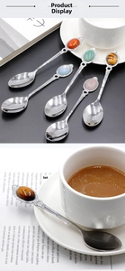 Detail of vintage stainless steel spoons with embossed handles and colorful gemstone ends