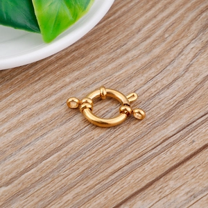 Golden round stainless steel spring clasp for DIY necklaces and bracelets on wood surface