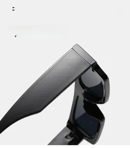 Close-up of polished black frame hinge and temple detail on narrow retro sunglasses