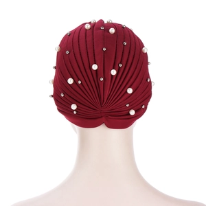 Detailed back view of a burgundy pleated turban cap with white pearls and silver beads