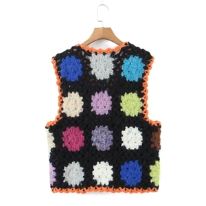 Gilet en crochet fait main avec motifs colorés et bords orange sur un cintre en bois