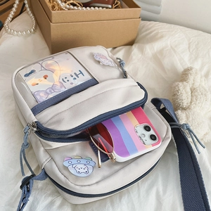 Détail du sac bandoulière en toile avec poche transparente montrant le rangement interne