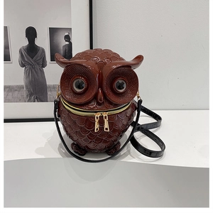 Detailed view of a brown owl shaped crossbody bag with metallic zipper and glossy finish
