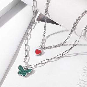 Double-layer silver necklace with a red heart pendant and a green butterfly charm