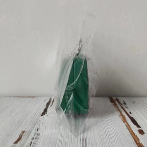 Detail of green Christmas candy tin box in protective packaging on wooden surface