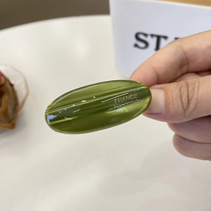 Olive green acetate hair clip with gold logo in handmade minimalist oval design