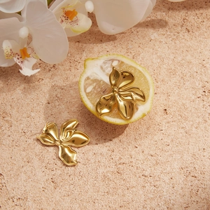 Golden flower earrings with 3D orchid petals shown on a fresh lemon backdrop