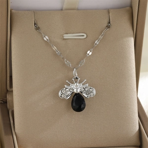 Gros plan du collier abeille argenté avec pierre noire facettée et strass brillants