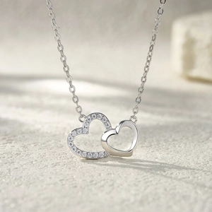 Macro detail of intertwined double heart pendant necklace with shimmering pavé set stones