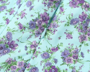 Detailed view of floral poplin dress featuring a hidden zipper and woven fabric texture