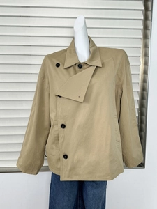 Detailed front view of khaki double-breasted short trench coat on mannequin