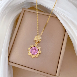 Elegant gold titanium necklace featuring a pink floral pendant with sparkling crystals