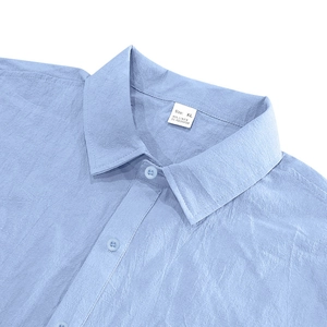 Detail of light blue linen shirt collar showing fabric texture and size XL label