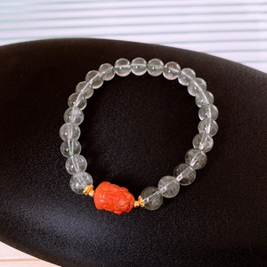 Close-up of S925 silver green phantom bracelet with orange carved piyao bead