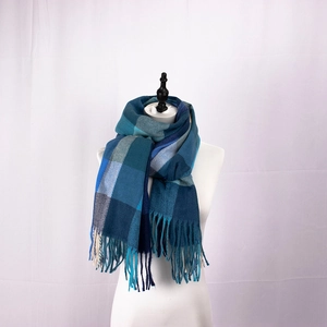 Detail of blue plaid scarf with long fringe tassels on a white mannequin display